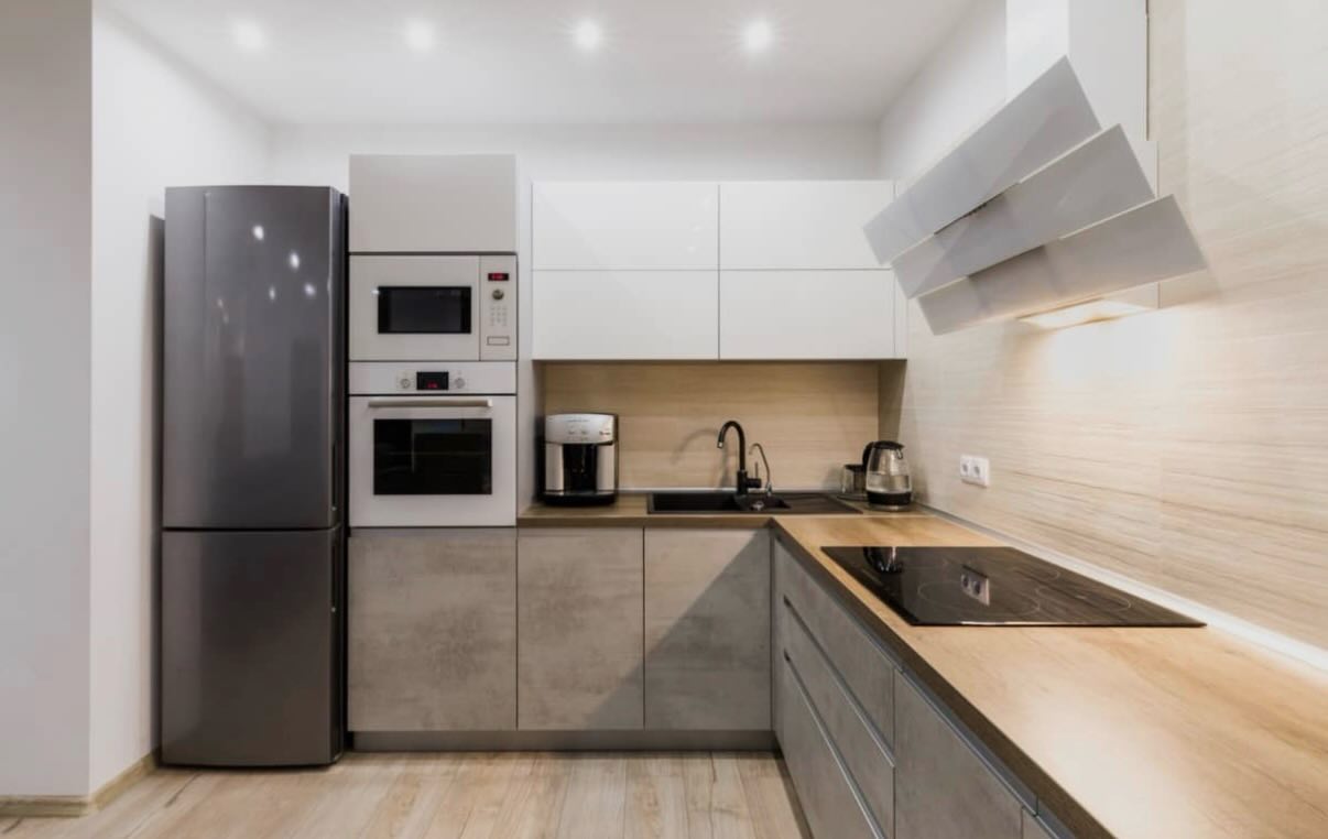 Cocina reformada en tonos grises y madera con electrodomésticos integrados