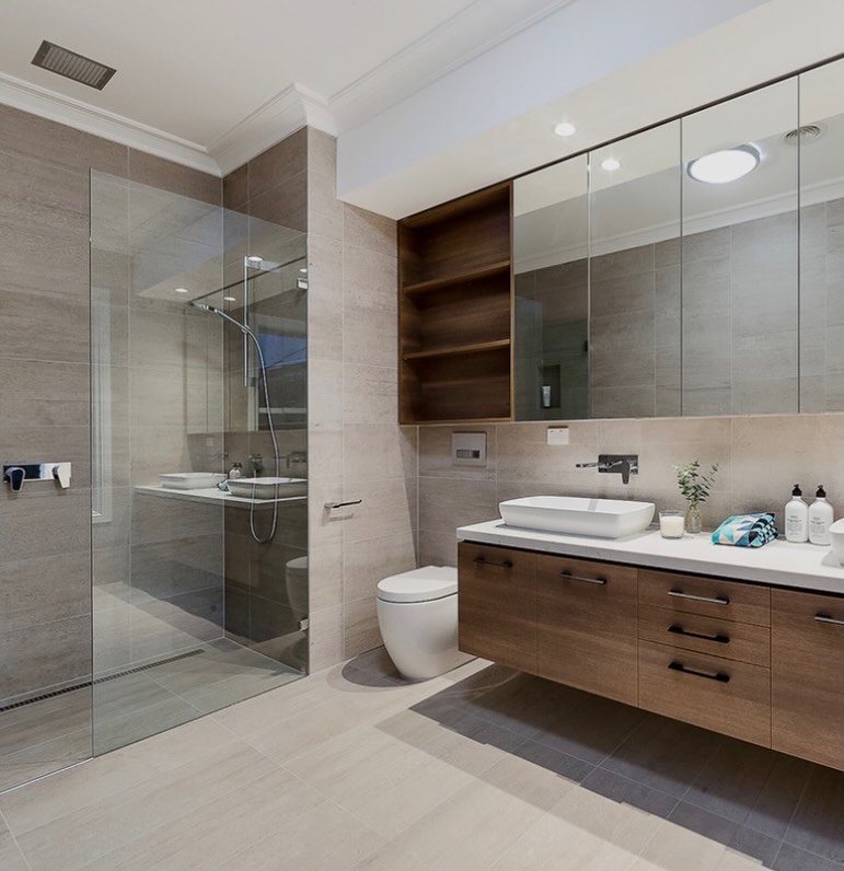 Baño reformado con mueble suspendido de madera y ducha con mampara de cristal