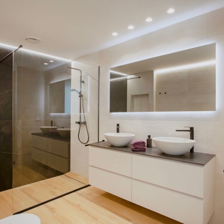 Baño reformado con doble lavabo, espejo retroiluminado y ducha de obra